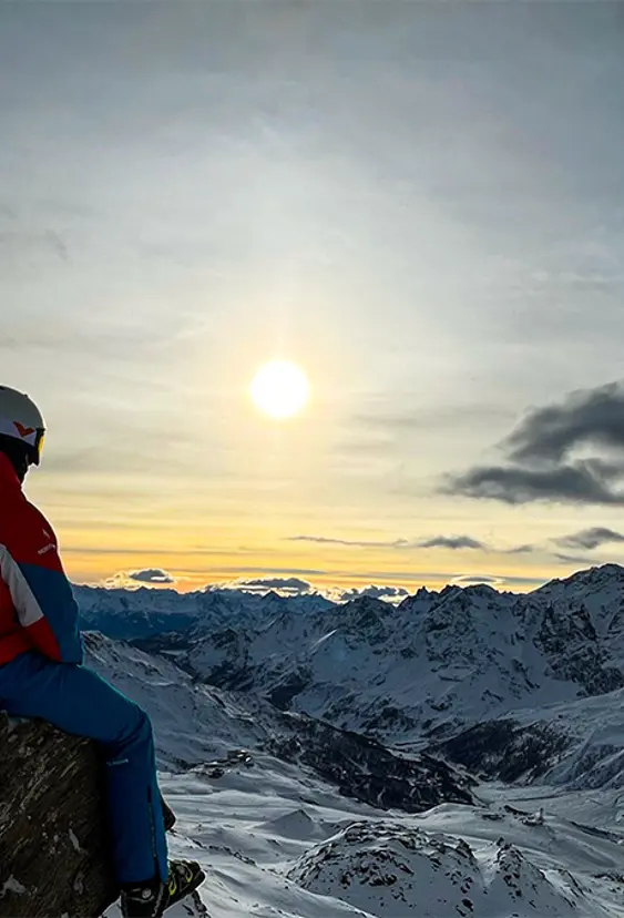 skiguide sidder og ser udover bjerge