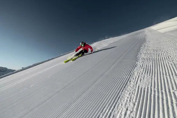 Skidåkare som åker skidor nerför flera pister i Ischgl, med 239 km pist i Silvretta - vinterupplevelse i Alperna.