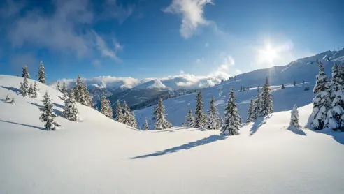 Det vackra landskapet, med snötäckta alptoppar och dalar under en klar blå himmel.