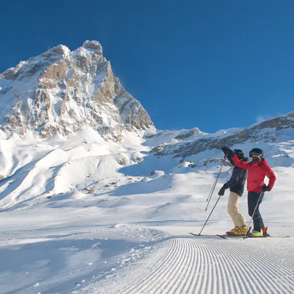 Cervinia är Italiens skidparadis, där två skidåkare står och beundrar den majestätiska utsikten över Matterhorn.