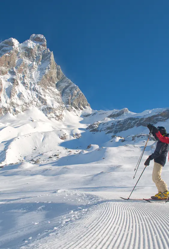 Cervinia är Italiens skidparadis, där två skidåkare står och beundrar den majestätiska utsikten över Matterhorn.