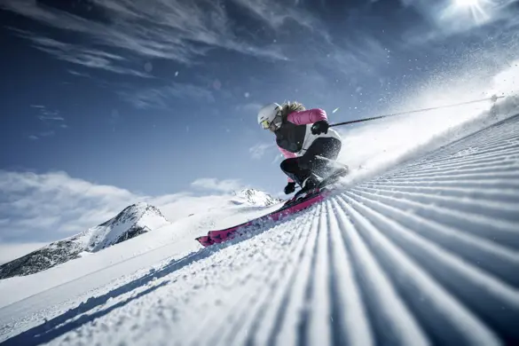 Skidåkare åker på nypistade skidbackar i Zell am See, Alperna, perfekt för en skidsemester i Österrike