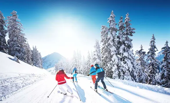 Fyra skidåkare åker skidor i Bad Gastein, Alperna, känd för sina utmärkta förhållanden för skidåkning.