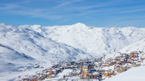 En vy över skidorten Val Thorens, Frankrike, med snötäckta berg och de tre dalarna (Les 3 Vallées) som sträcker sig ut i horisonten, där många boenden erbjuder Ski-In/Ski-Out access för enkel åtkomst till skidbackarna.