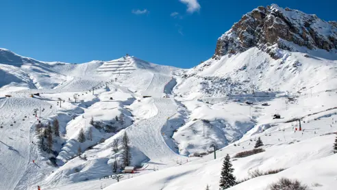 Bild från skidområdet i Canazei, där skidåkare kan välja att åka nerför backarna från Marmolada, Dolomiterna, och njuta av utmanande pister och enastående vyer över dalen och bergen.